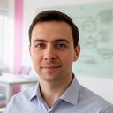 Senior DBA portrait in a bright office with database diagrams on a glass board