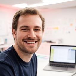 Jordan, a DBeaver trainer, smiling beside a bright training desk with laptop open